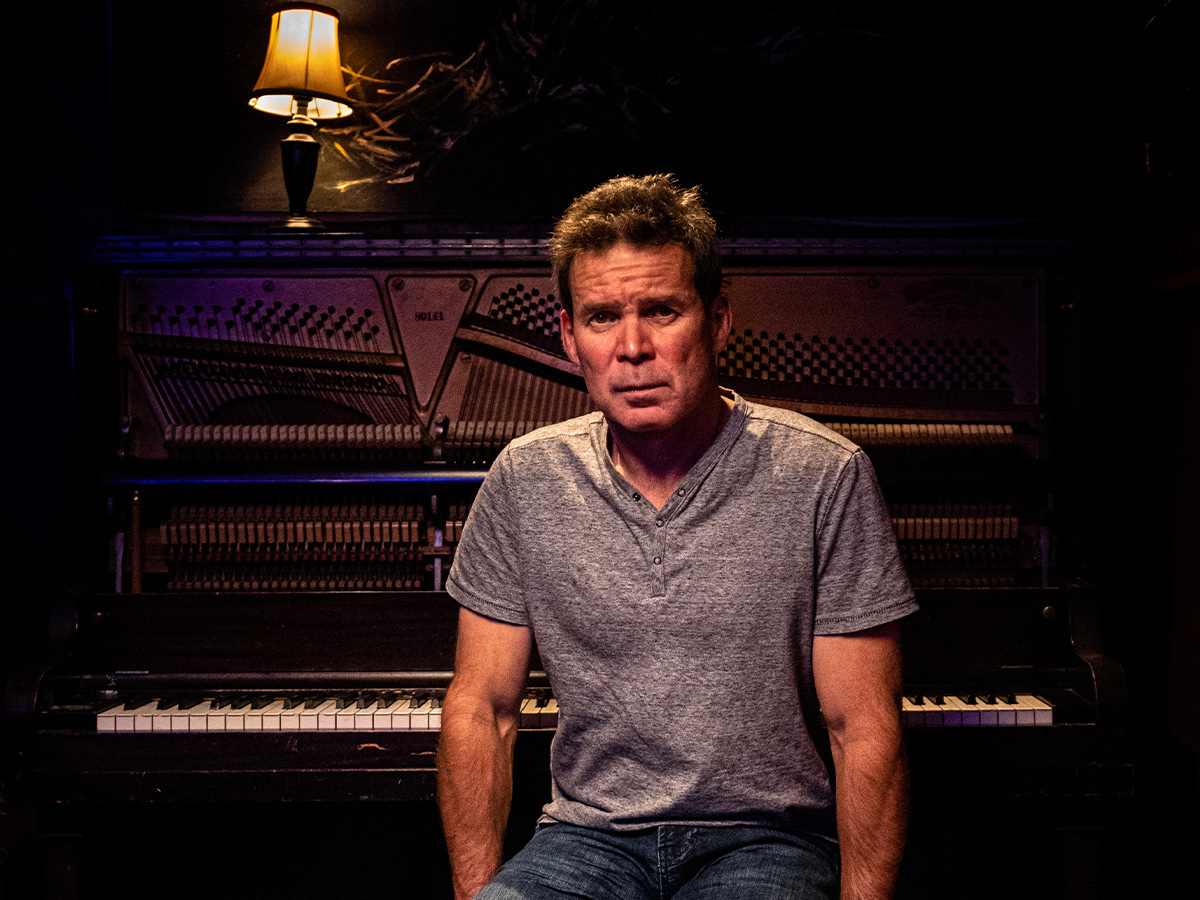 Portrait of Gord Sinclair sitting with a piano